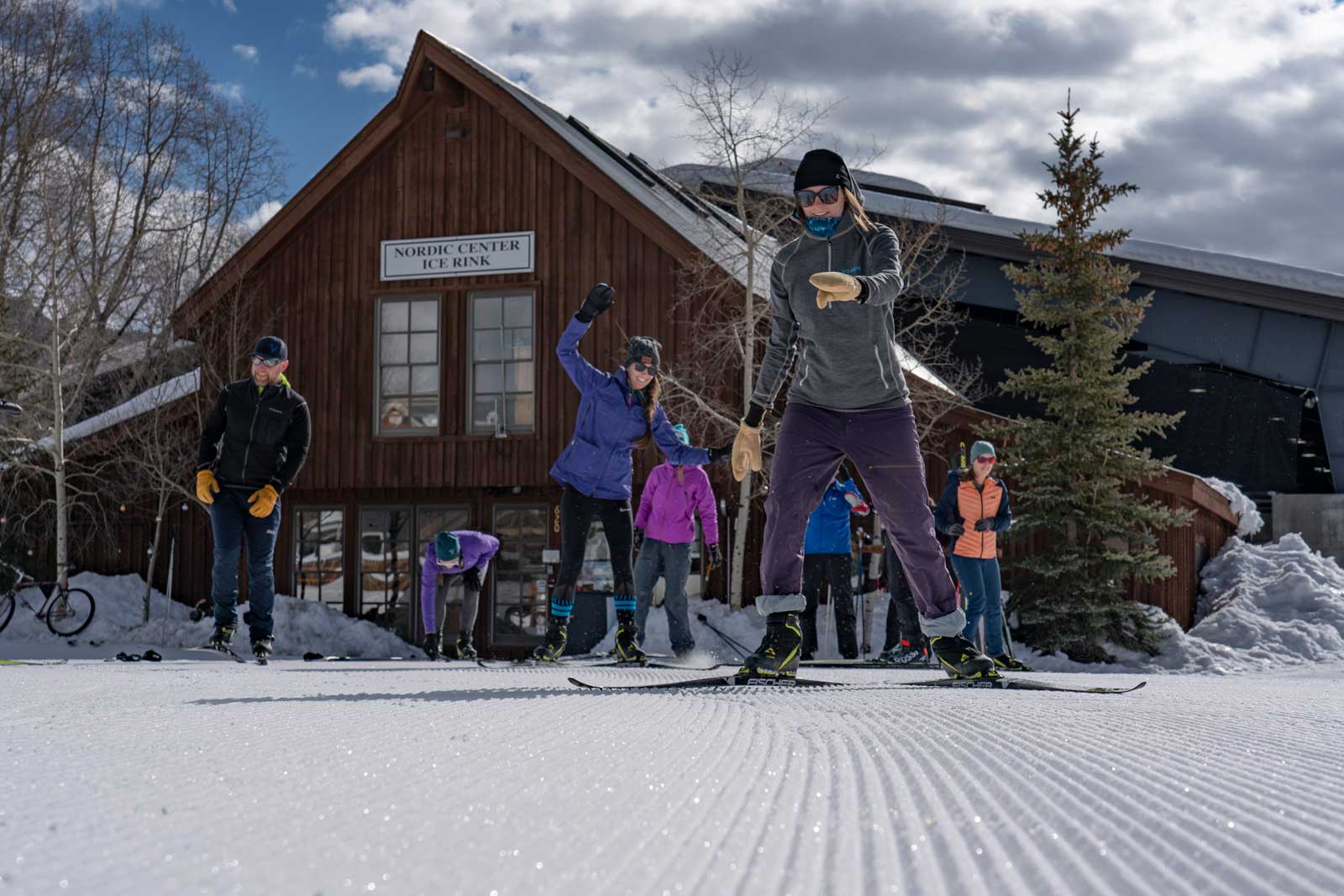 A group of people suit up with cross-country skis at the nordic center in Crested Butte and start to teeter-toter onto the trail
