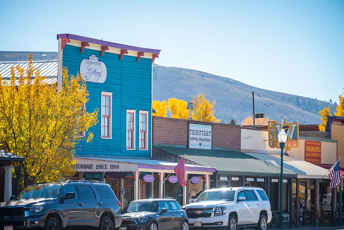 Charming coffee shop building and Main Street surrounded by golden aspen trees in fall