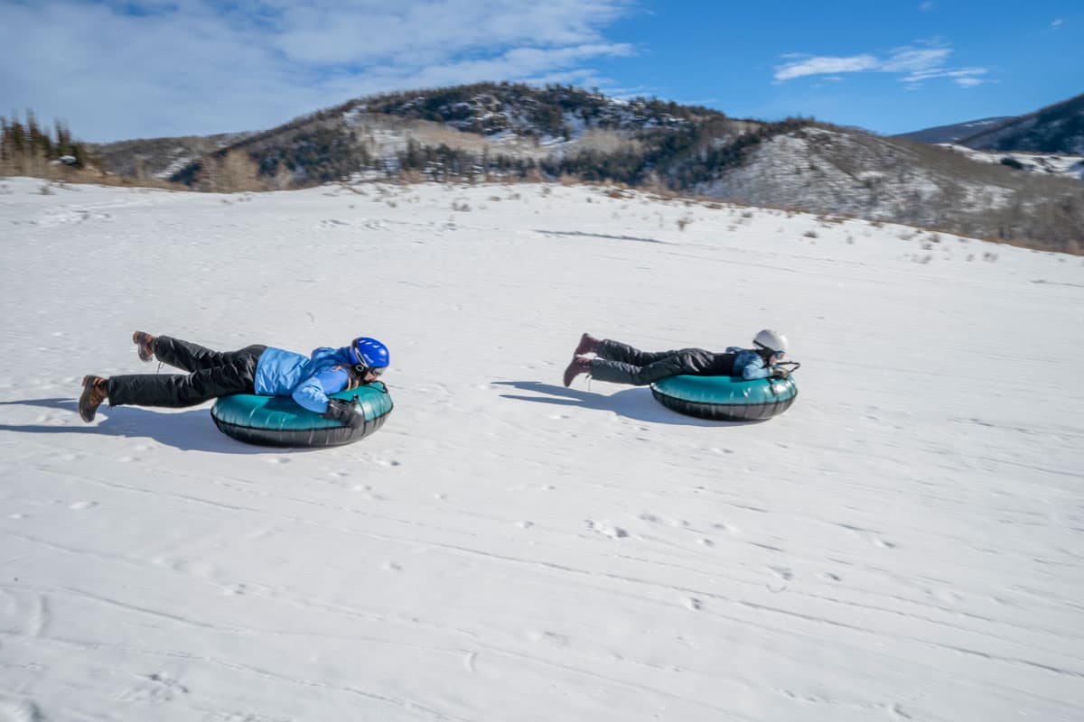 Family snow tubing on snowy hills at Vista Verde in Colorado