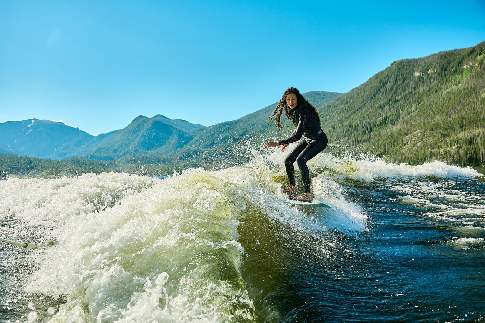A surfer rides waves in the Colorado River