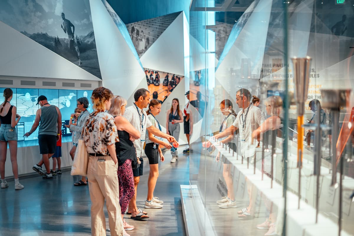 People stand in front of floor-to-ceiling glass cases and marvel at the torch collection of the U.S. Olympic & Paralympic Museum in Colorado Springs