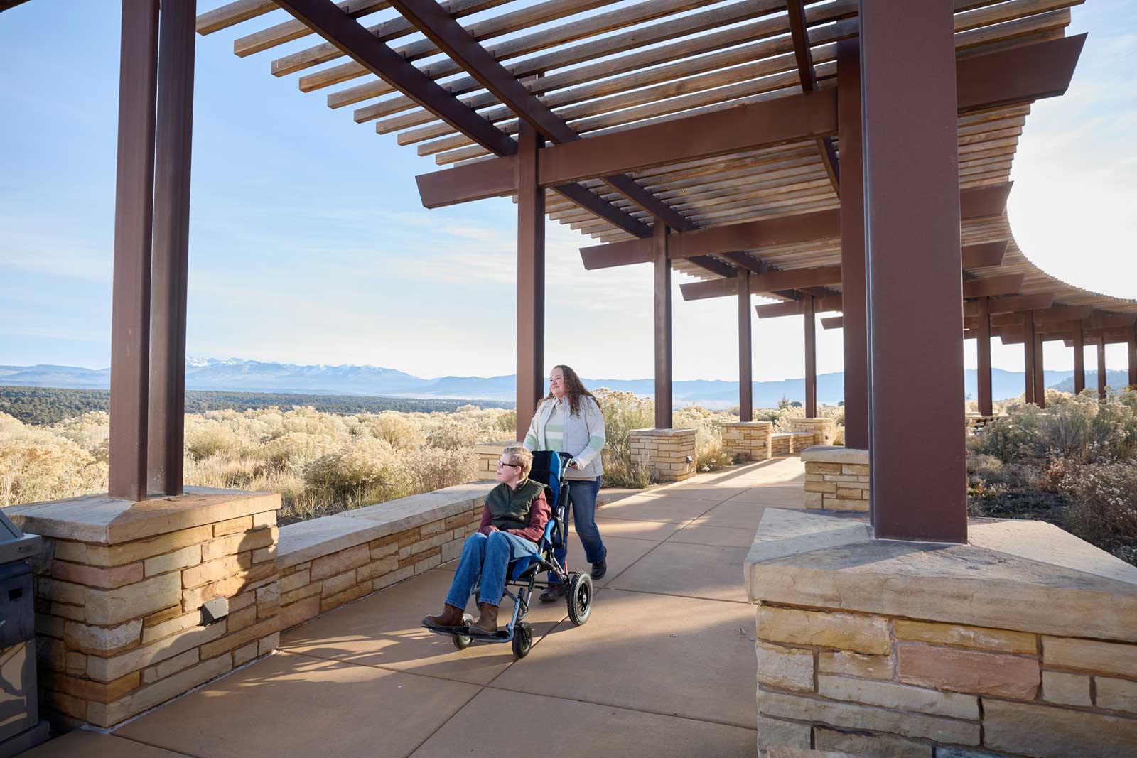 One person pushes another in a wheelchair at the visitor center at Mesa Verde National Park
