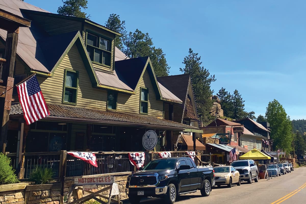 Downtown Evergreen street lined with stores and shops with flags hanging outside.
