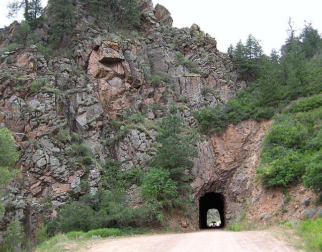 A car tunnel is bored through a mountain peak
