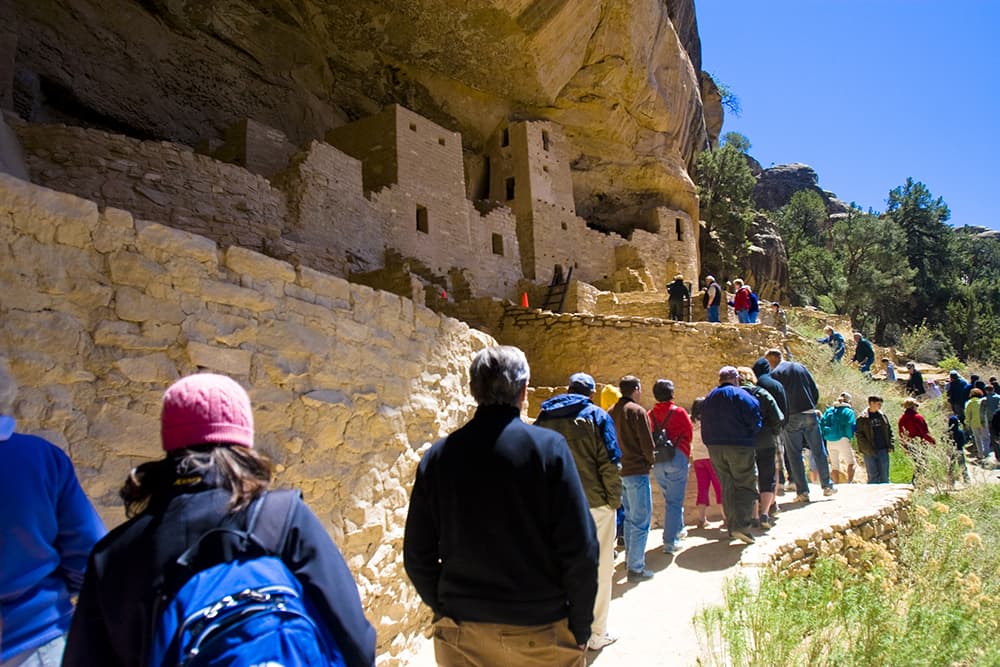 people looking at the cliff dwellings in mesa verde national park