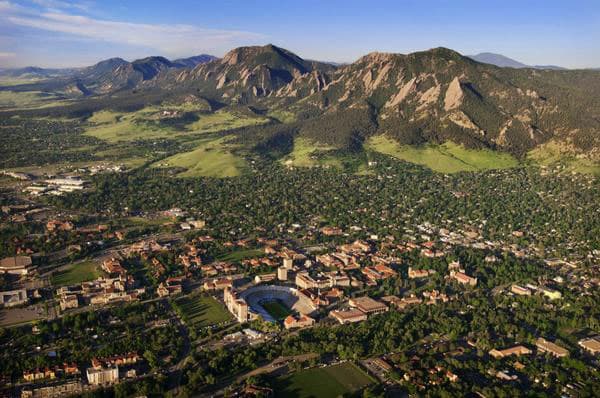 An aerial view of the CU campus in Boulder where the buildings meet the Flatiron mountains.