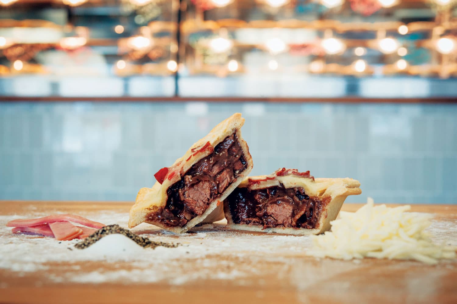 Two halves of a cut steak pie shows a meat-packed filling with thick gravy at Waltzing Kangaroo in Fort Collins, Colorado.