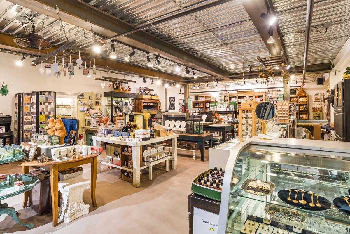 The Stanley Marketplace in Aurora, Colorado, features an array of products on an eclectic collection of tables. Items for sale range from large white mugs to clay statues of standing bears.
