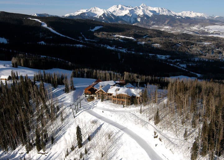 Aerial view of Allred's Restaurant, covered in snow with snowcapped mountains in the background